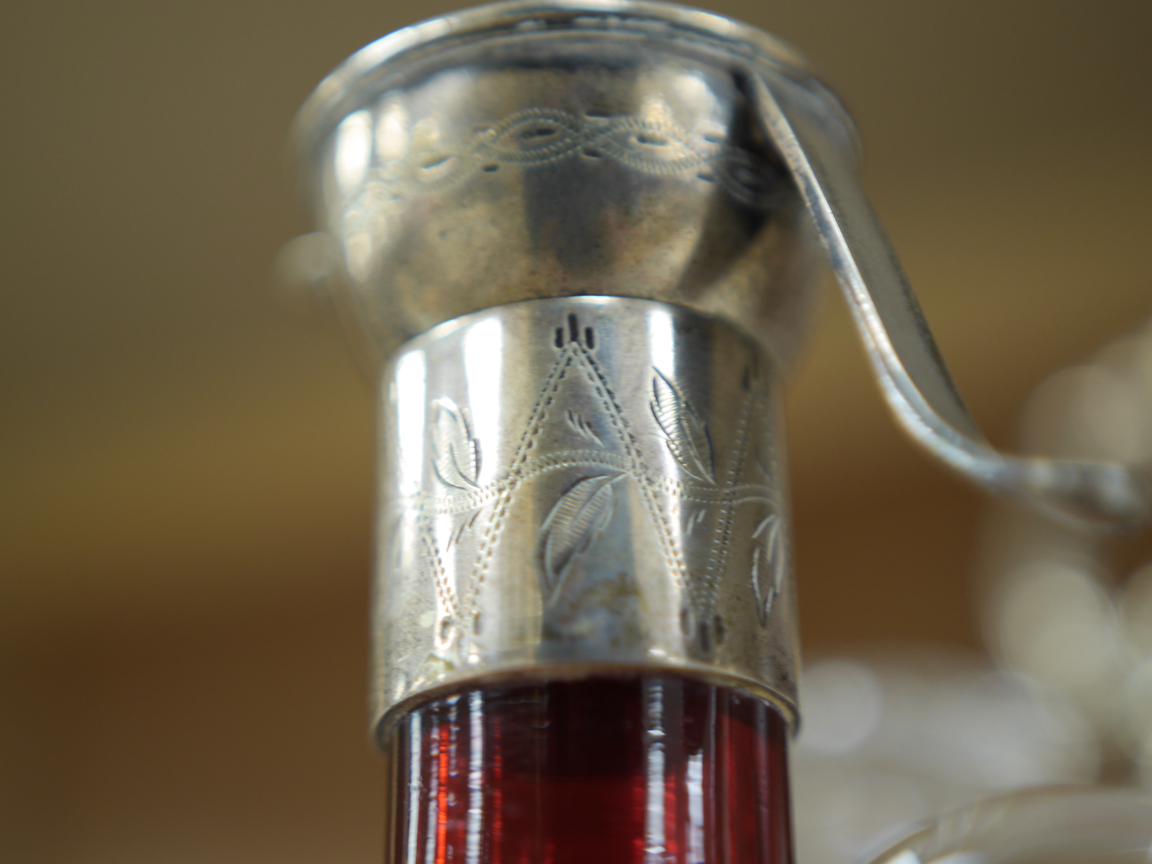 A cased silver plated three bottle liqueur stand, a cranberry decanter, sugar shaker and jam stand together with a green glass shaker, stand 27cm high (5). Condition - all items in good condition, box in need of a clean